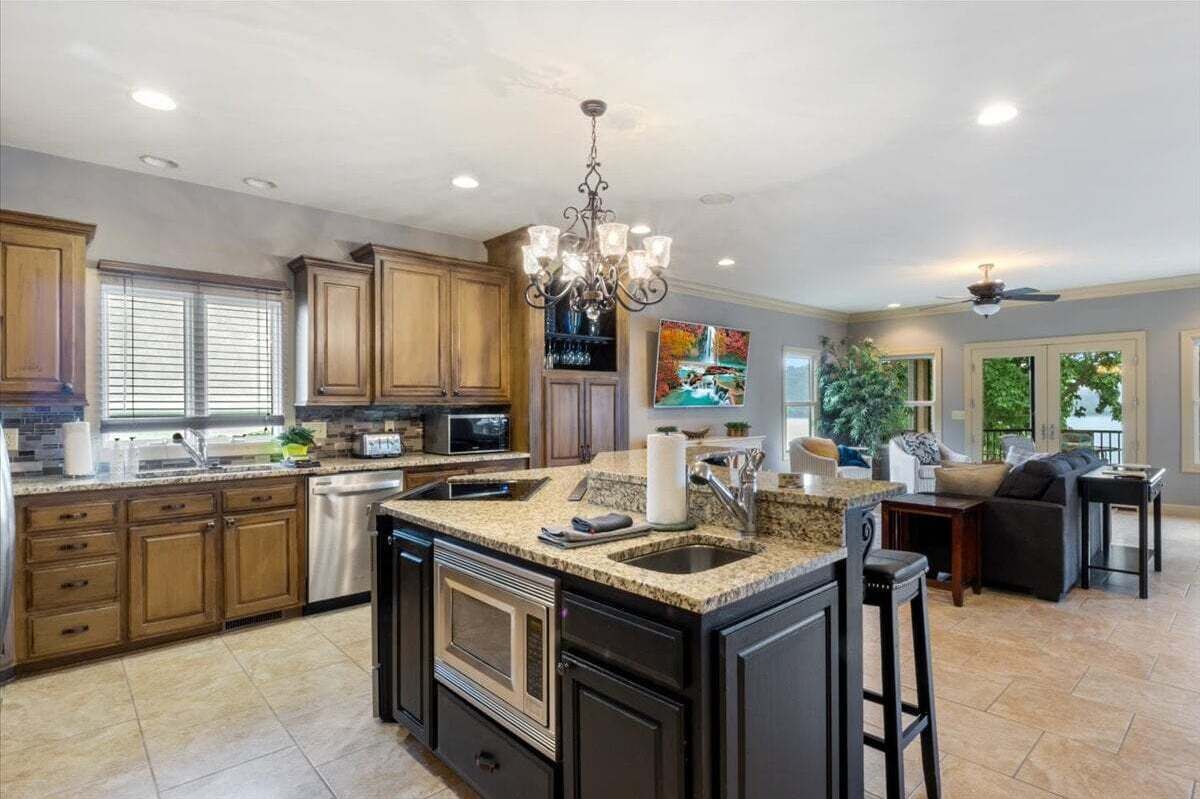 A spacious kitchen with granite countertops, wooden cabinets, and a central island.