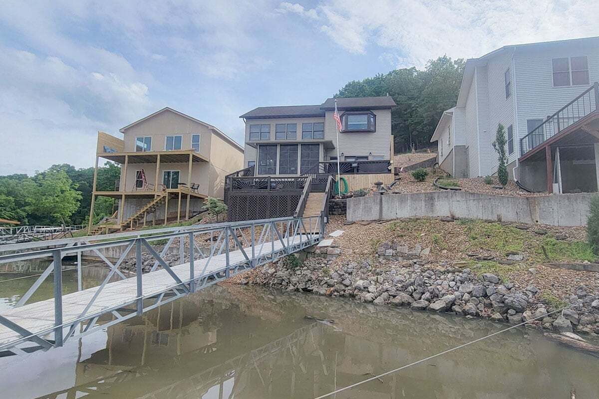 Ein Wohngebiet mit einer Brücke über dem Wasser, verbunden mit Häusern mit einer Holzterrasse.