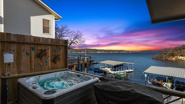 A hot tub on a deck overlooking a body of water with boats and docks.