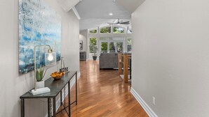 A hallway with wooden flooring, a modern light fixture, and a large abstract painting. - Kahokee Trail Lodge-pedal Boat, and Nearby Restos (Rocky Mount)