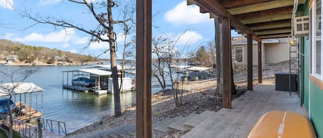 A covered outdoor area with a view of a lake and docked boats.