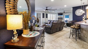 A modern kitchen with a large island, a dining area with a leather sofa, and a bar area with stools. - Nautical-inspired Lakefront Unit w/ Awesome Views (Osage Beach)