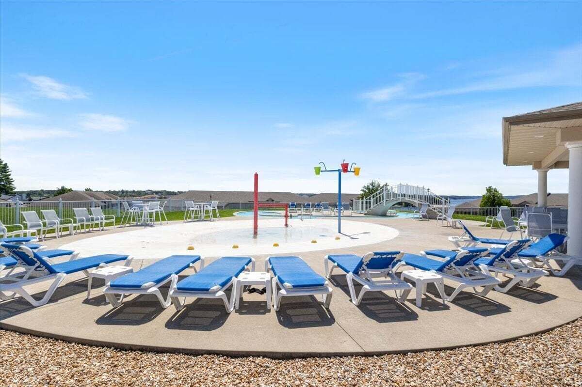 Ett poolområde med solstolar och en vattenrutschkana.