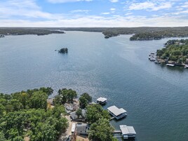 Uma propriedade à beira do lago com casas flutuantes, cais e margem arborizada.