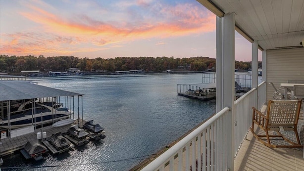 A waterfront view from a covered deck with docked boats and a chair. - Newly Updated, Amazing Views, Boat Slip & Heated Pool (Sunrise Beach)