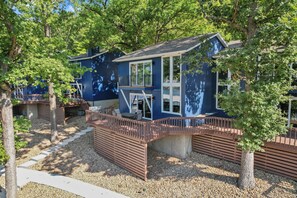 Een blauw gebouw met een balkon en een houten terras.