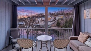 Un balcon donnant sur la ville, une table, deux chaises et un canapé.