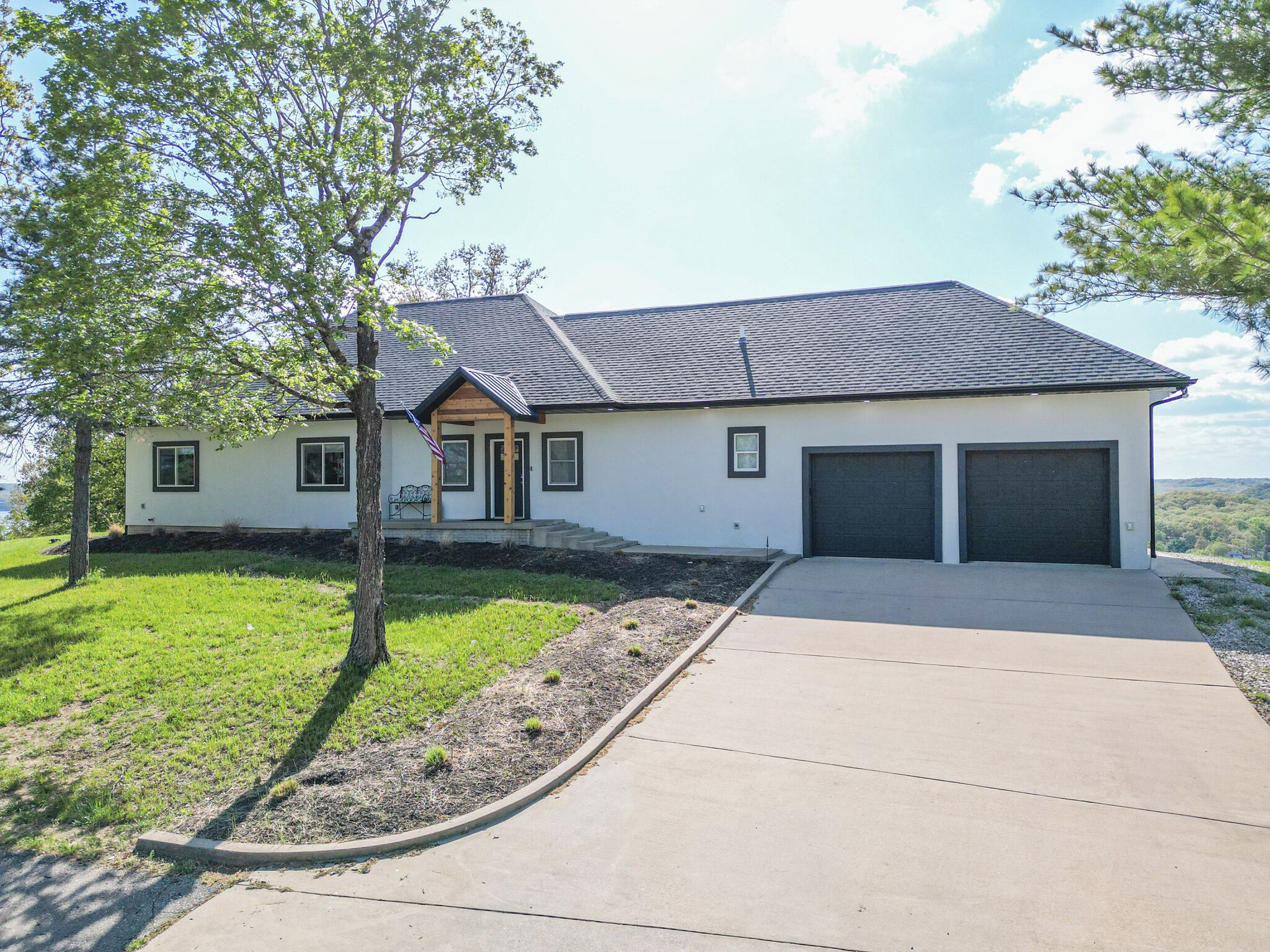A modern two-story house with a garage, a front porch, and a well-maintained lawn.