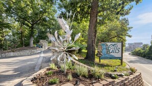 A roadside sign for Eastshore with a decorative metal sculpture in the foreground. - Lakefront 1st-floor Condo, Screened Patio, Pools & Courts (Lake Ozark)