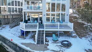Une maison à deux étages dotée d’un balcon, d’un patio couvert et d’un petit espace extérieur aménagé pour s’asseoir.
