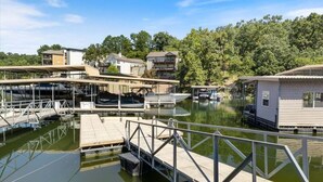 Un port de plaisance avec des bateaux amarrés, une jetée en bois et une petite construction qui ressemble à une maison, située sur la droite.