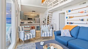A modern living room with striped armchairs, a blue sofa, and a coffee table.