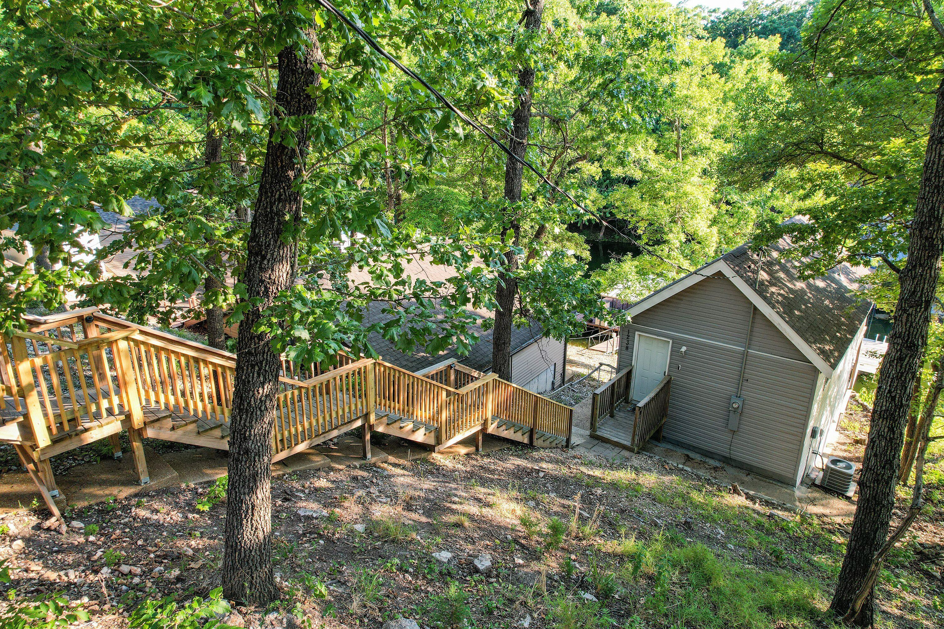 A wooden deck with a staircase leading to a garage.
