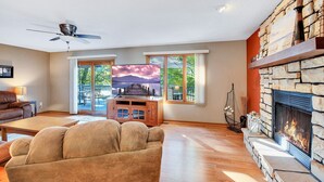 Ein Wohnzimmer mit Kamin, Fernseher und einer Steinwand.