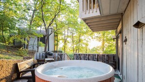 A hot tub on a wooden deck with outdoor furniture and a covered area. - Great Location, Margaritaville Amenities & Hot Tub (Osage Beach)