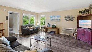 A living room with a sofa, a coffee table, a TV, and a fireplace. - Great Location, Margaritaville Amenities & Hot Tub (Osage Beach)