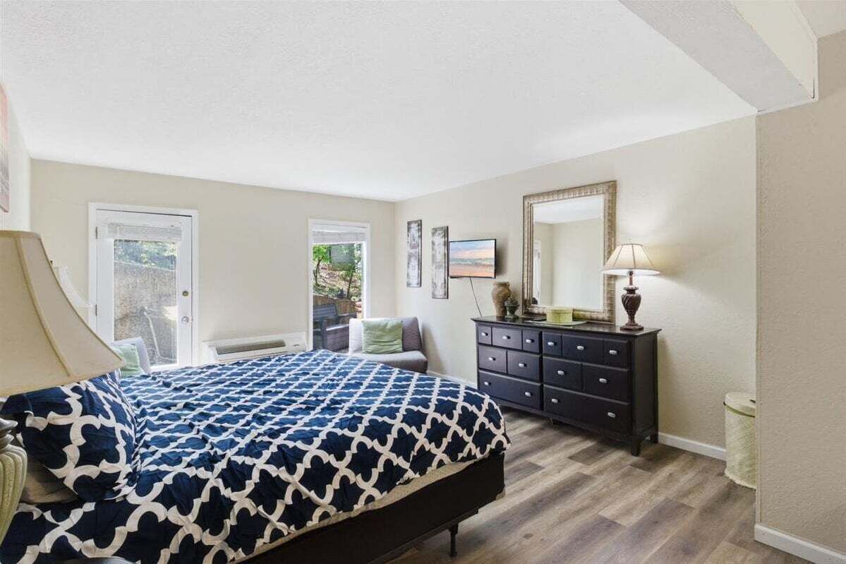 A bedroom with a bed, dresser, and a large mirror.