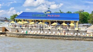 A beachfront restaurant named "Landshark Bar & Grill" with outdoor seating and umbrellas. - Perfect Resort Retreat Close to Everything (Osage Beach)