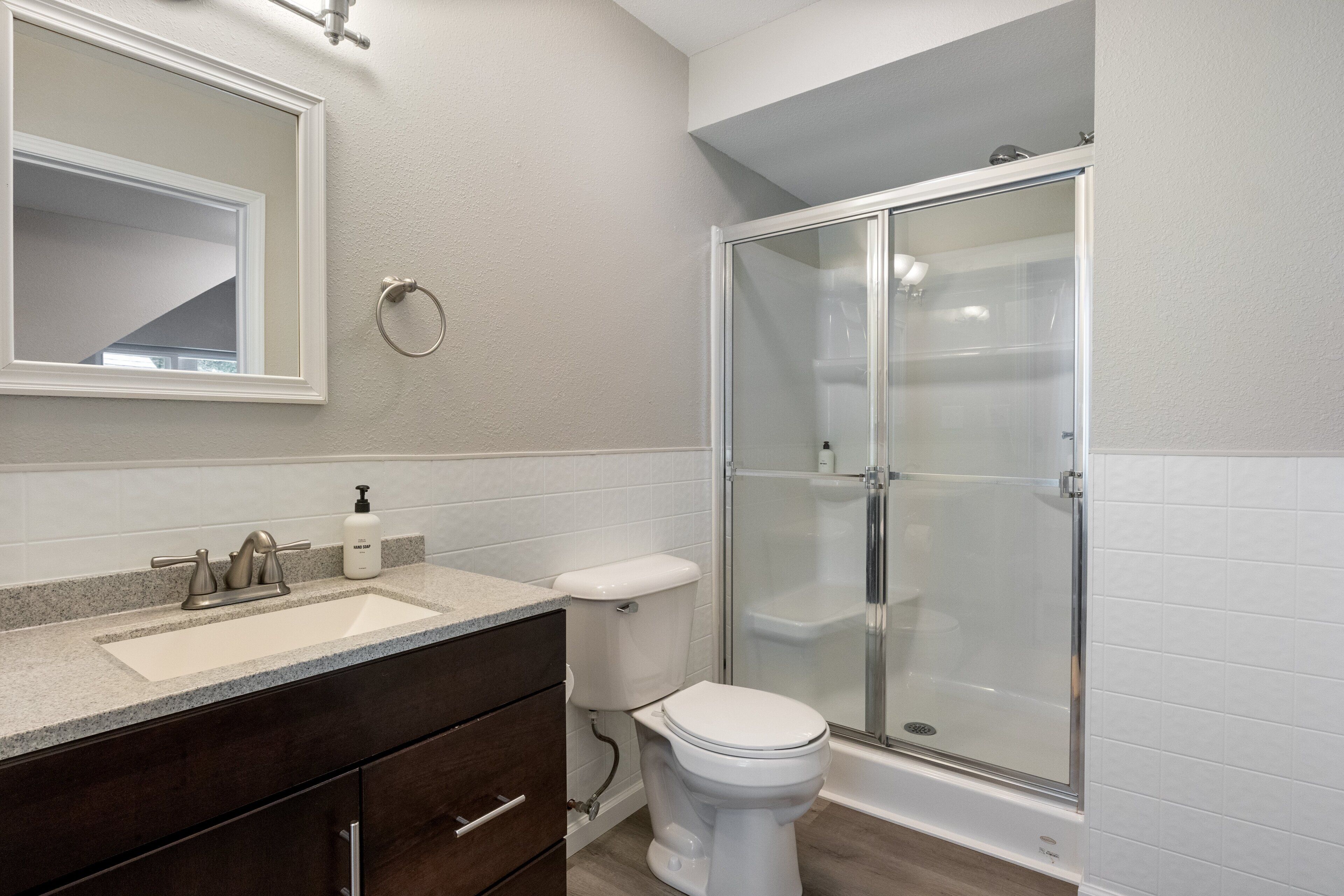Une salle de bain équipée d’un lavabo, de toilettes et d’une douche à parois en verre.