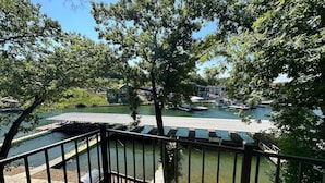 Une vue sur le fleuve, avec une terrasse en bois, un quai et des bateaux.