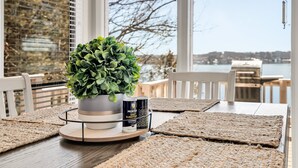 A dining table with a potted plant, a can of Morton Salt, and woven placemats. - Amazing Views Close to the Strip - Private Dock! (Lake Ozark)