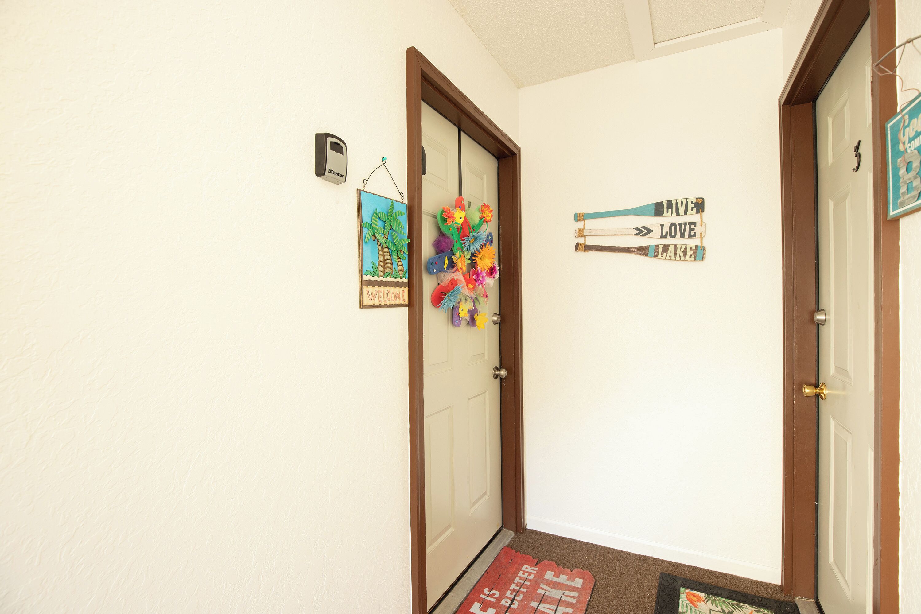 Um corredor com uma placa de boas-vindas, decoração colorida na parede e placas de sinalização.