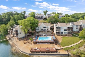 A resort with a pool area, multiple buildings, and a lake. - Dream Condo With Perfect Location for All The Fun! (Osage Beach)