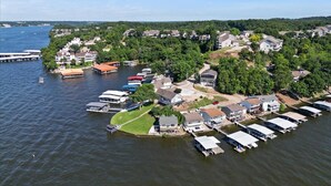 An aerial view of a lakeside residential area with houses, docks, and boats.
