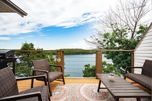 A deck with wicker furniture, a grill, and a view of a lake. - Amazing Views From Balcony, Loft & Gated Pool (Kaiser)