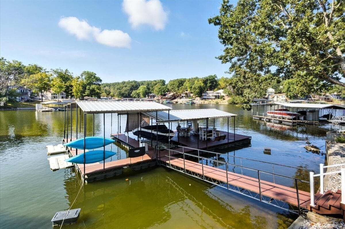 Un muelle flotante con zona de estar cubierta y una embarcación.