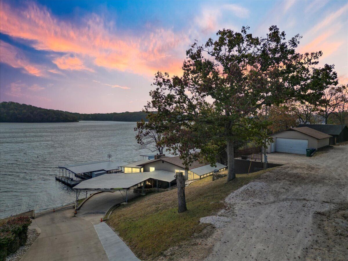 A lakeside property with a dock, a covered outdoor area, and a garage.