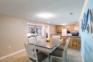 Una cocina compacta con una mesa, sillas y un refrigerador.