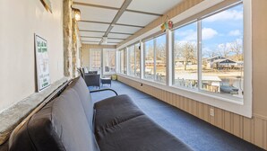 Ein überdachter Außenbereich mit einer Bank, einem Tisch und Stühlen.