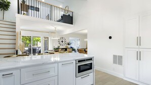 A modern kitchen with a large island, white cabinetry, and a built-in oven. - Newly Remodeled w/ Dock, Boat & PWC Slips, Pool Table & Golden Tee (Osage Beach)
