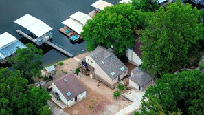Vista aérea de una propiedad frente al lago, con varias casas, un muelle y un bote.