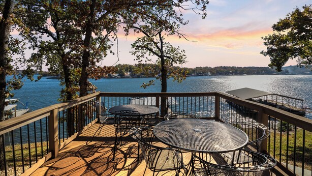 Eine Terrasse mit Gartenmöbeln mit Blick auf einen See.