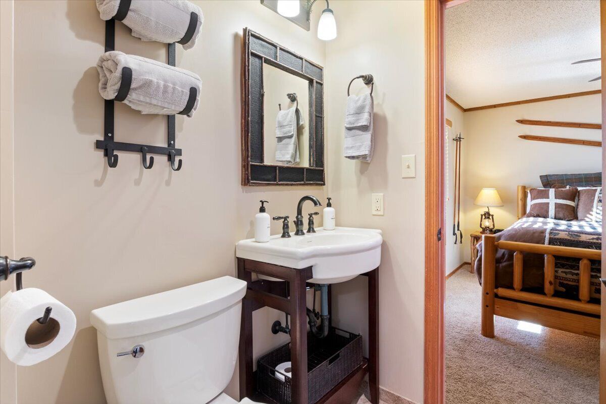 Un baño con inodoro, lavabo y barra para toallas.