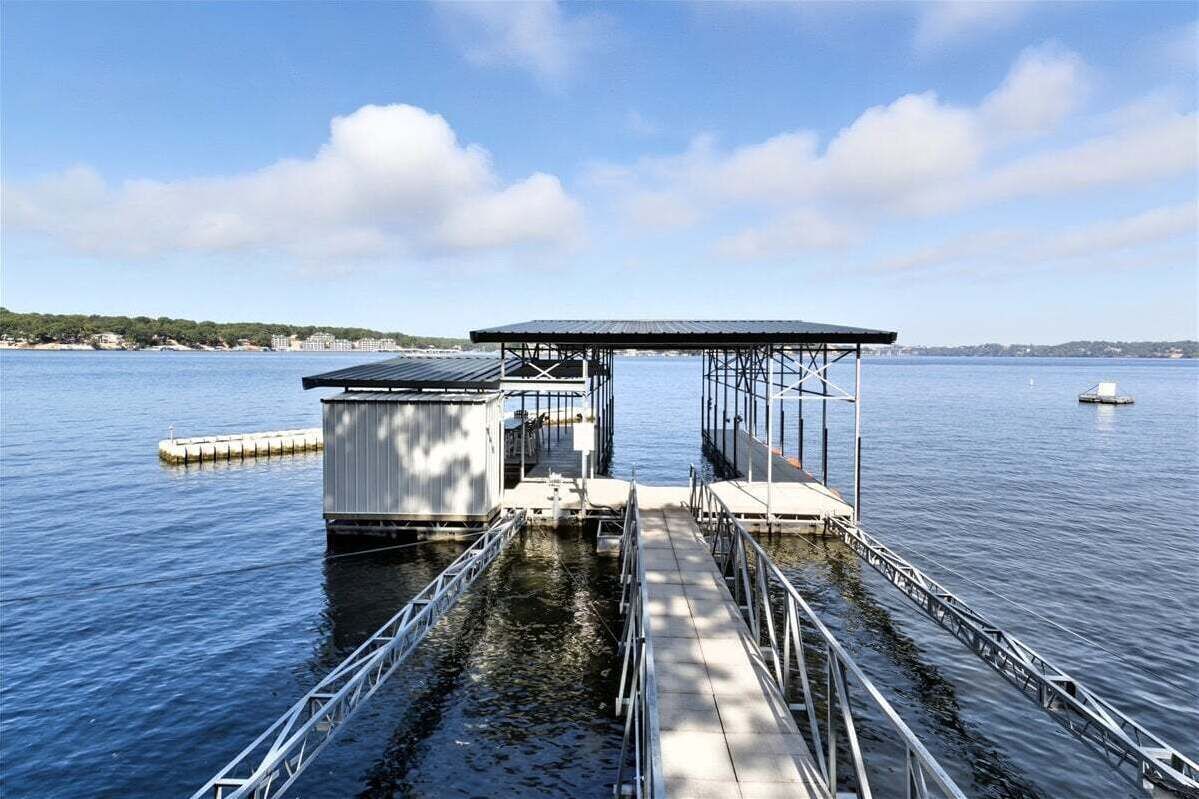 Une jetée dotée d’une structure abritée, d’une rambarde métallique et offrant une vue dégagée sur l’eau.