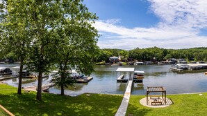 A lakeside view with docked boats, a gazebo, and a grassy area with trees. - Great Location & Lake Views, Boat Slip (Lake Ozark)