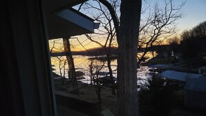 A view from inside a building looking out to a body of water with trees and a dock. - Lakefront Escape, Sunrise Views, Boat Slip & Community Dock Access (Roach)