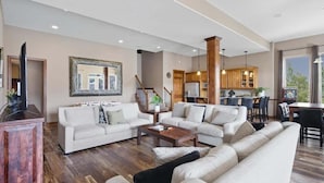 Un salon spacieux, comprenant un grand canapé, une table basse et un meuble en bois.