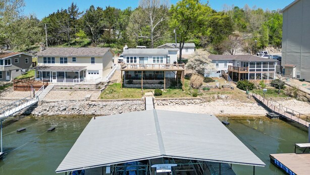 Una propiedad frente al agua con varias casas, un muelle y un edificio grande con techo de metal.