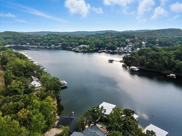 A lake surrounded by dense forest and residential buildings. - Expansive Deck, Beautiful Views, Private Dock & Boat Slip (Sunrise Beach)