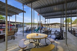 A covered outdoor area with tables and chairs, a flag, and a water pump.
