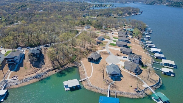Vue aérienne d’un quartier résidentiel au bord d’un lac, avec des maisons et des quais.