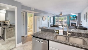 A modern kitchen with granite countertops, stainless steel appliances, and a view to the dining area. - Lakeview Condo w/ 2 Pools & Beach - Family Fun Awaits at 21mm (Osage Beach)