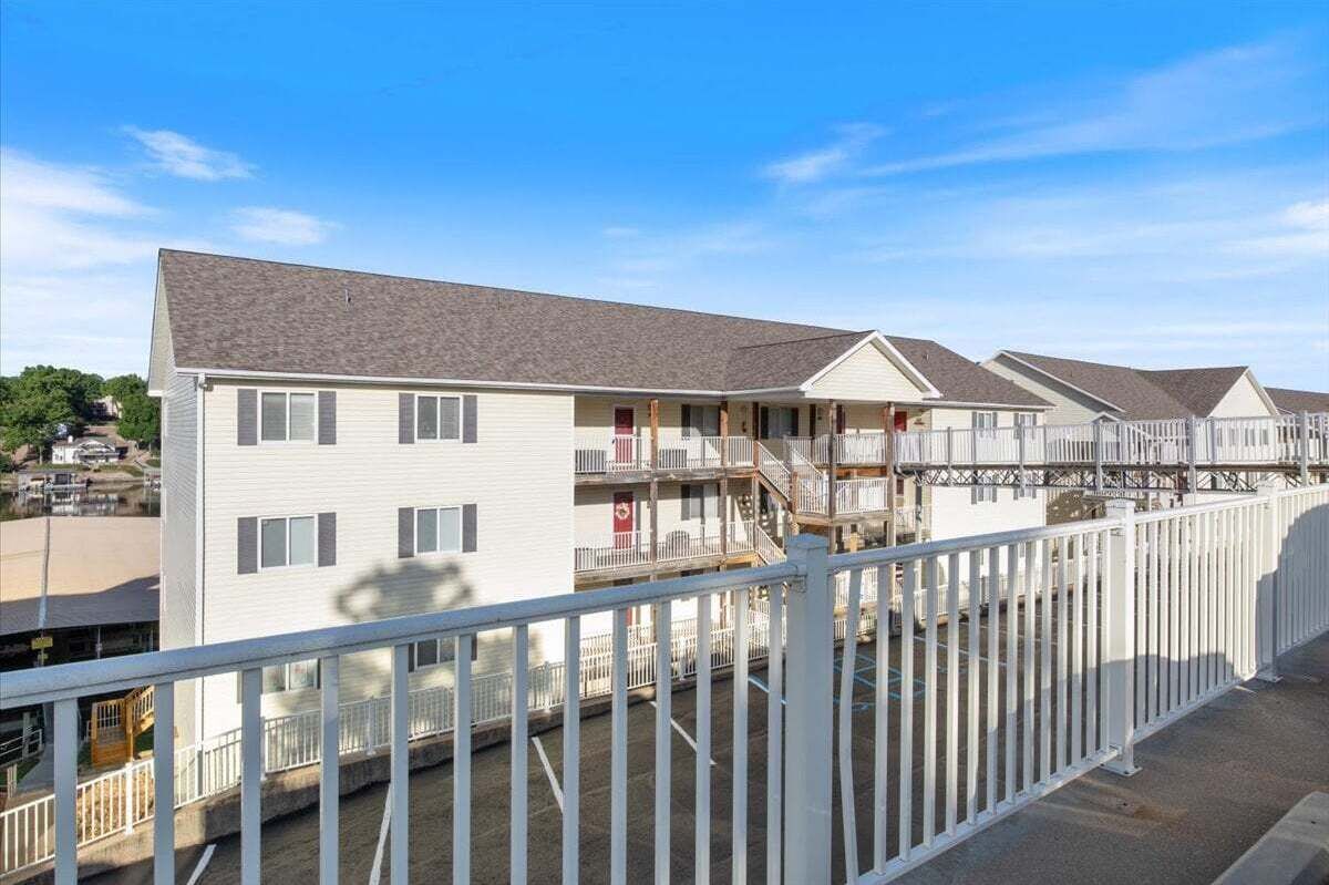 A row of motel buildings with a white exterior, multiple stories, and balconies.