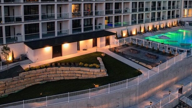 A multi-story hotel with balconies, a swimming pool, and a landscaped garden area. - Family-fun Lakeside Luxury at Topsider in Osage w/ 2 Pools, Prime Views Pack N' Play & Games (Osage Beach)