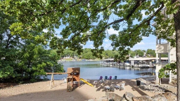 A lakeside park with a wooden play structure, seating area, and a dock extending into the water. - Family-perfect Lakefront Fun at The Ledges, 21mm, 2 Pools & Beach (Osage Beach)