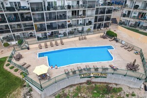 Un hotel de varios pisos con piscina, mobiliario exterior y un cartel que dice "CEDAR HEIGHTS".